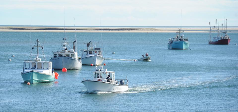 A crew from the Harwich harbormaster's office navigates past the Chatham fishing fleet during the search for the plane that crashed Halloween night off Nauset Beach in Orleans.