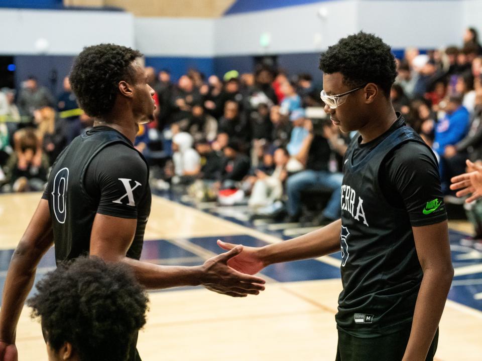 Bronny James high fives brother Bryce James at the Sierra Canyon vs Christ The King boys basketball game at Sierra Canyon High School on December 12, 2022