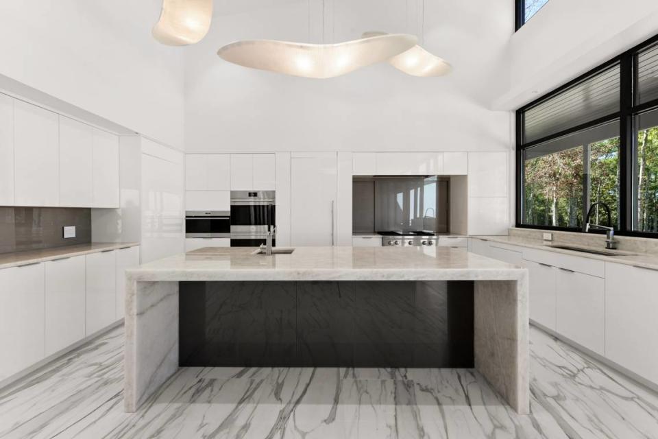 The modern kitchen in this home built by Fritz Development has modern pendants, strung with airplane wire and weighted so they don’t sway when the air conditioner comes on.