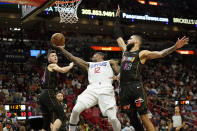 Los Angeles Clippers guard Eric Bledsoe (12) goes to the basket as Miami Heat guard Tyler Herro, left, and forward Caleb Martin (16) defend during the second half of an NBA basketball game, Friday, Jan. 28, 2022, in Miami. (AP Photo/Lynne Sladky)