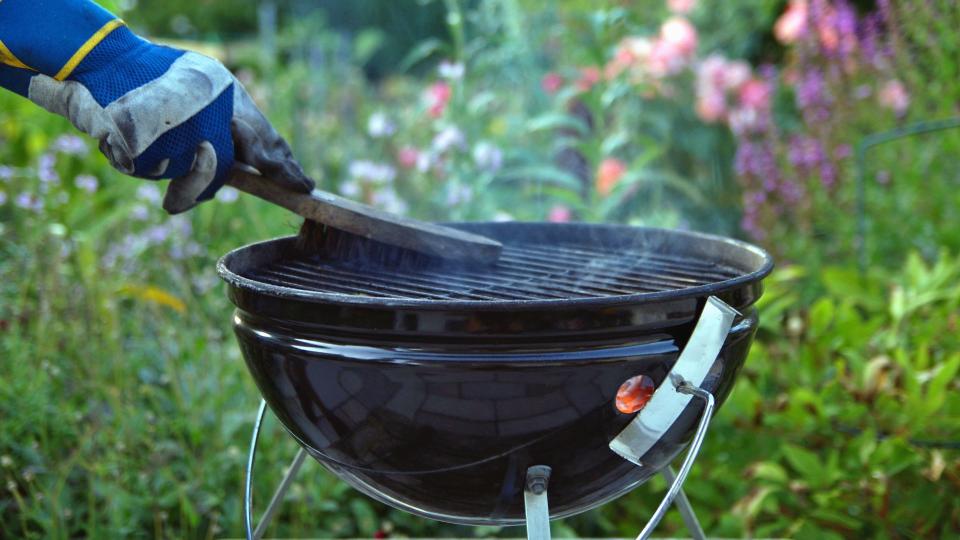 Charcoal grill being cleaned