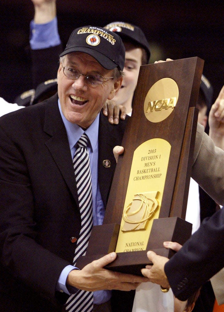 FILE -Syracuse head coach Jim Boeheim accepts the national championship trophy after the Orangemen beat Kansas 81-78 at the Final Four on Monday, April 7, 2003, in New Orleans. Syracuse coach Jim Boeheim is retiring after 47 years of leading the university's basketball program, the team announced Wednesday, March 8, 2023 after a loss knocked them out of the ACC Conference Tournament. (AP Photo/Michael Conroy, File)