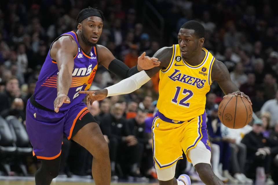 Los Angeles Lakers guard Kendrick Nunn (12) drives against Phoenix Suns forward Josh Okogie during the first half of an NBA basketball game, Monday, Dec. 19, 2022 in Phoenix. (AP Photo/Rick Scuteri)