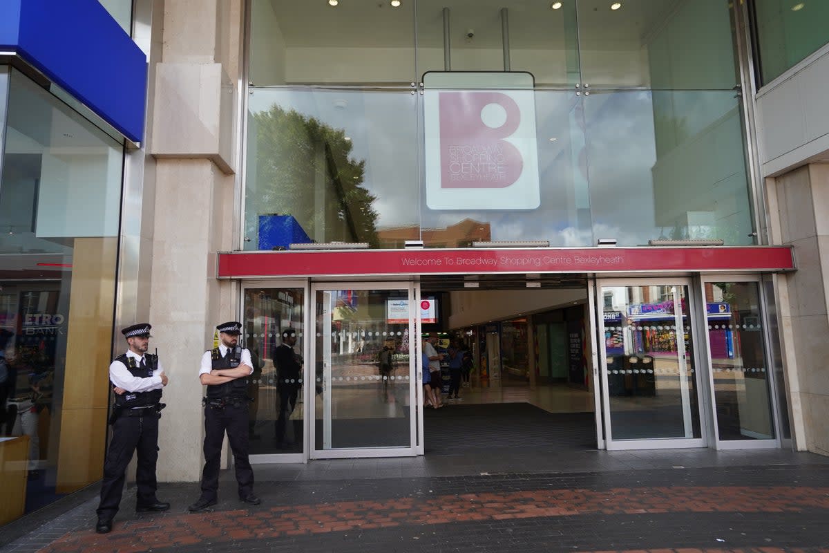 Police officers stand outside the Broadway Shopping Centre in Bexleyheath, southeast London, where businesses have been warned to prepare for 