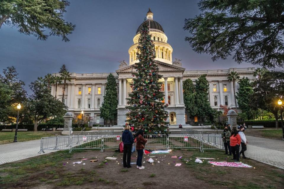 Participants in a Sacramento Regional Coalition for Palestinian Rights rally make an appearance at Capitol Christmas tree on Tuesday. There will be a virtual tree lighting ceremony on Wednesday.
