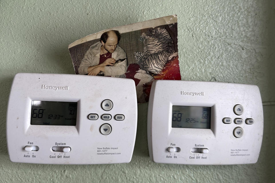 A photo of Tony Cavallaro and his pet alligator Albert is displayed on thermostats inside the custom enclosure he built for the reptile in his house, in Hamburg, N.Y., March 19, 2024. Albert was seized by the Department of Environmental Conservation in mid-March, 2024. (AP Photo/Carolyn Thompson)