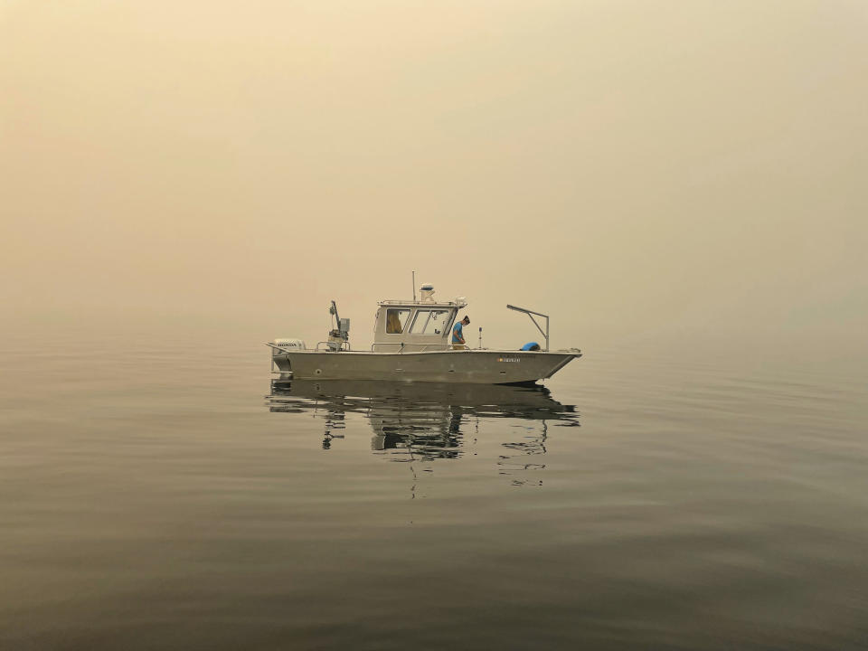 This photo provided by UC Davis shows Brandon Berry, a researcher at the University of California Davis Tahoe Environmental Research Center, collects on a research vessel in Lake Tahoe, Calif. on Aug. 23, 2021. Scientists say it's too soon to draw definite conclusions about the lasting damage that record-setting wildfires will have on Lake Tahoe. But they're not wasting time. Many plan to bring their research plans to the Tahoe Science Advisory Council when it convenes for a scheduled meeting Thursday Sept. 16, 2021. (Katie Senft/UC Davis via AP)