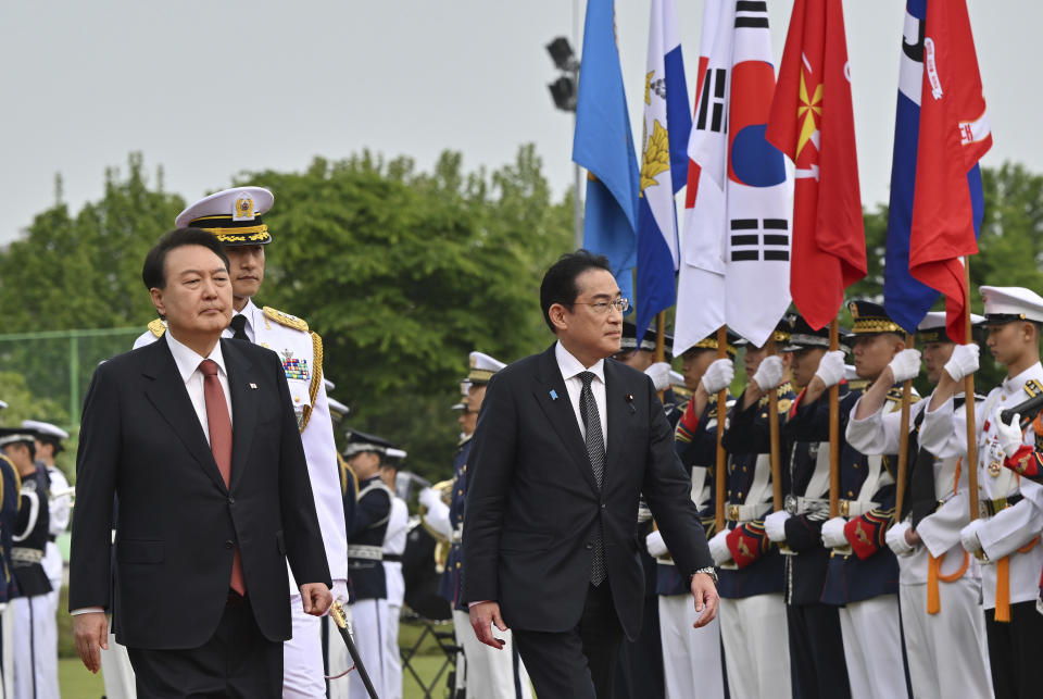 Japanese Prime Minister Fumio Kishida, right, and South Korean President Yoon Suk Yeol attend a welcoming ceremony at the presidential office in Seoul Sunday, May 7, 2023. (Jung Yeon-je/Pool Photo via AP)