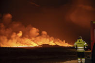 A volcanic eruption is seen, turning the sky orange, in Grindavik on Iceland's Reykjanes Peninsula, Monday, Dec. 18, 2023. (AP Photo/Marco Di Marco)