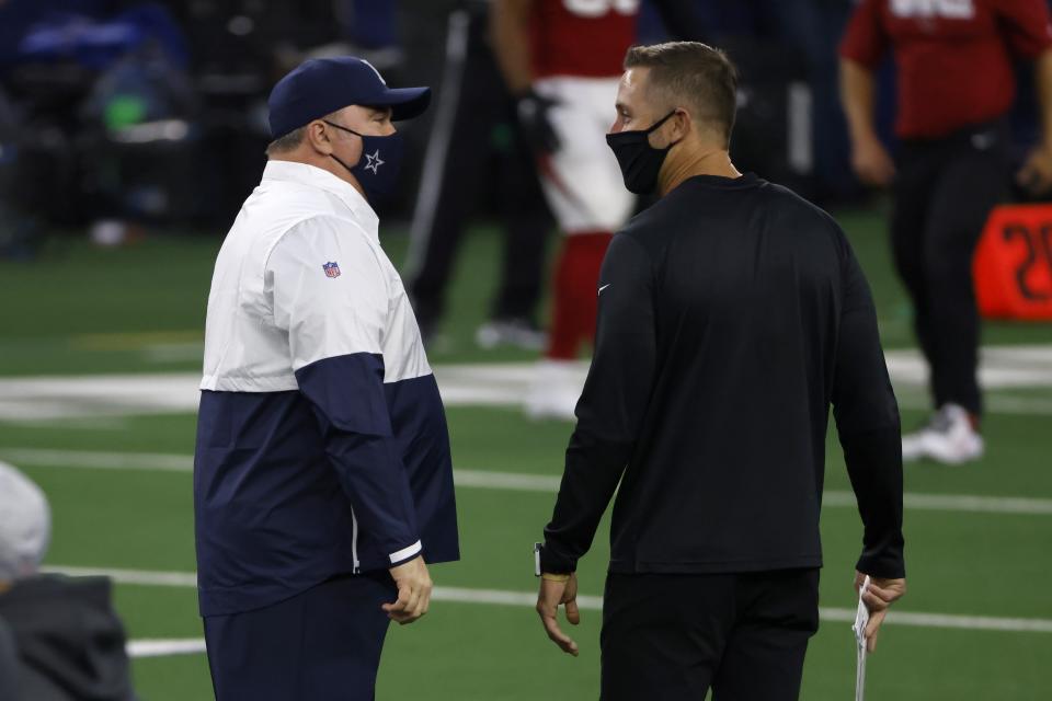Dallas Cowboys head coach Mike McCarthy, left, and Arizona Cardinals head coach Kliff Kingsbury, right, greet each other on the field during warmups before an NFL football game in Arlington, Texas, Monday, Oct. 19, 2020. (AP Photo/Ron Jenkins)