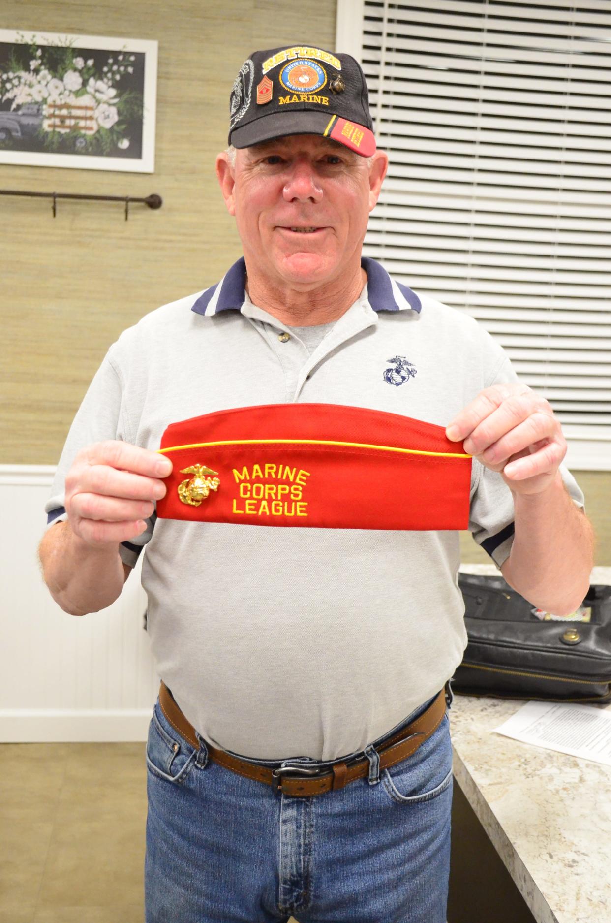 Marine Corps veteran Gary McElhiney holds a garrison cap at a Marine Corps League meeting in Fairview, Tenn., on March 23, 2022.