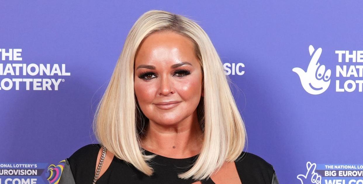 jennifer ellison red carpet appearance, smiling, wearing black outfit with cutout detail