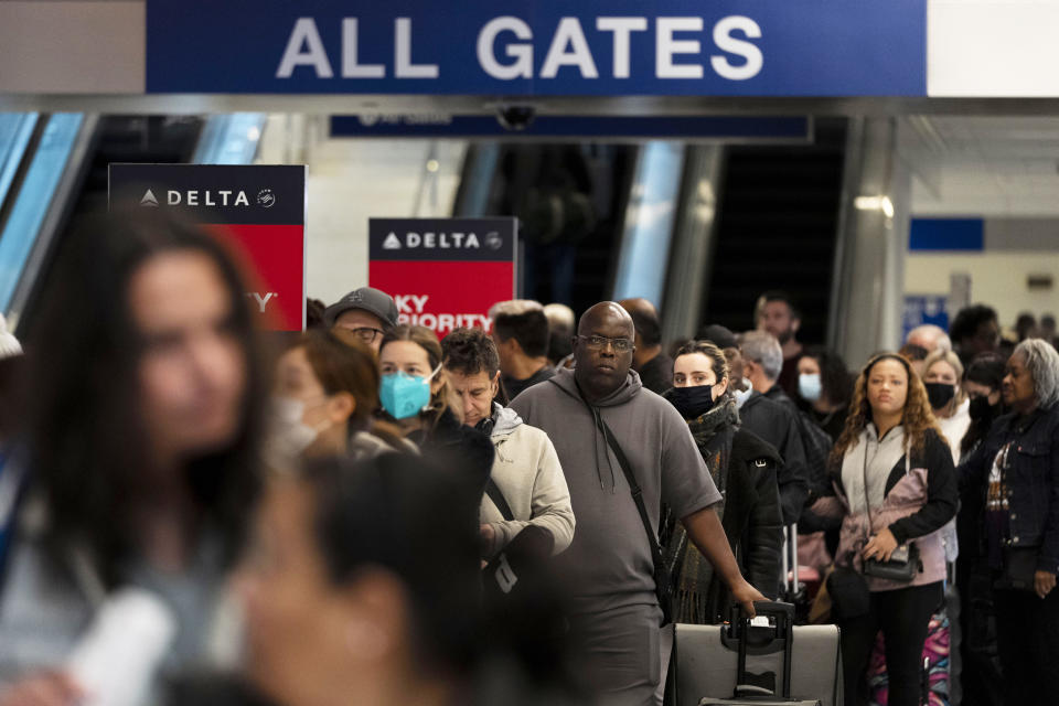 Travelers wait in line to check in at a ticketing counter at the Los Angeles International Airport (Jae C. Hong / AP)