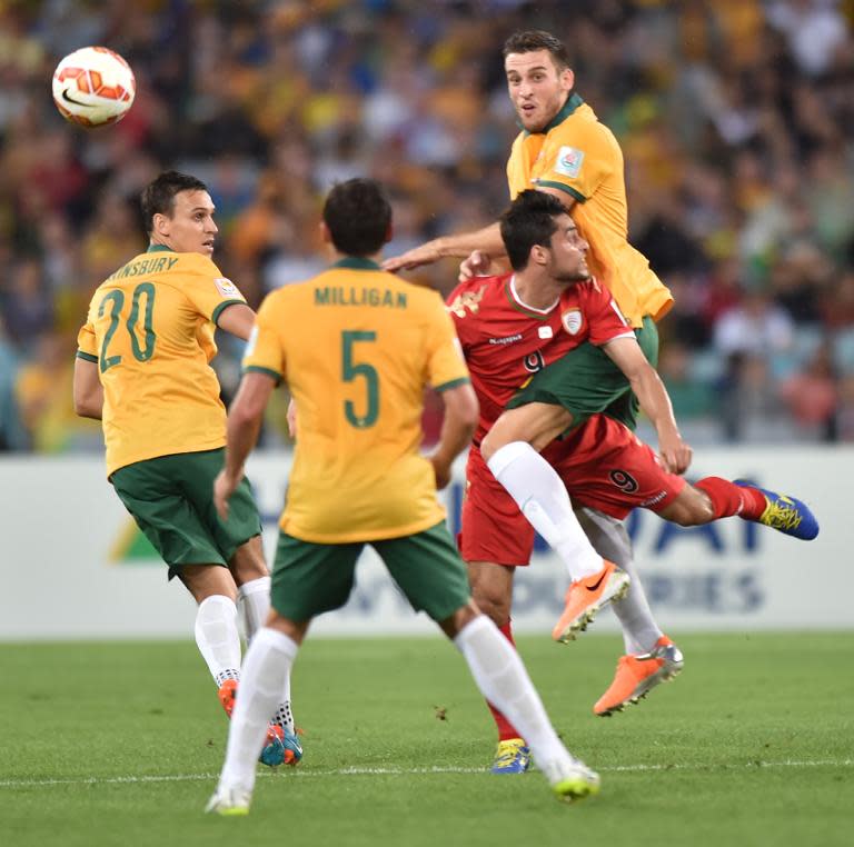 Matthew Spiranovic of Australia and Adul Aziz Al -Maqbali of Oman (2nd right) fight for the ball as Australia's Mark Milligan (2nd left) and Trent Sainsbury (left) look on during their AFC Asian Cup match in Sydney on January 13, 2015