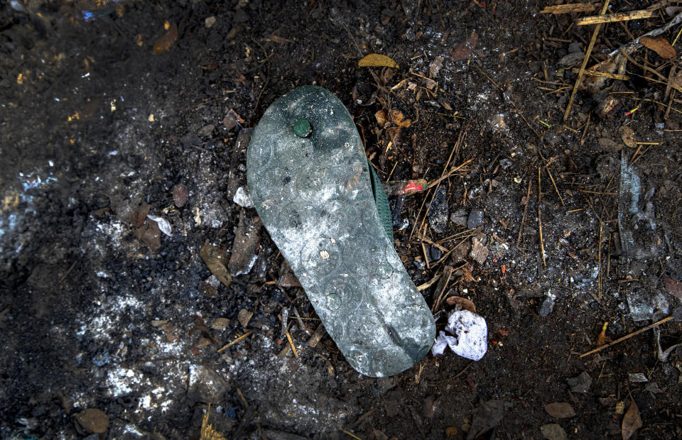 A used sandal of a deceased COVID-19 victim lies in a cremation ground in Gauhati, India, Friday, July 2, 2021. The personal belongings of cremated COVID-19 victims lie strewn around the grounds of the Ulubari cremation ground in Gauhati, the biggest city in India’s remote northeast. It's a fundamental change from the rites and traditions that surround death in the Hindu religion. And, perhaps, also reflects the grim fears grieving people shaken by the deaths of their loved ones — have of the virus in India, where more than 405,000 people have died. (AP Photo/Anupam Nath)