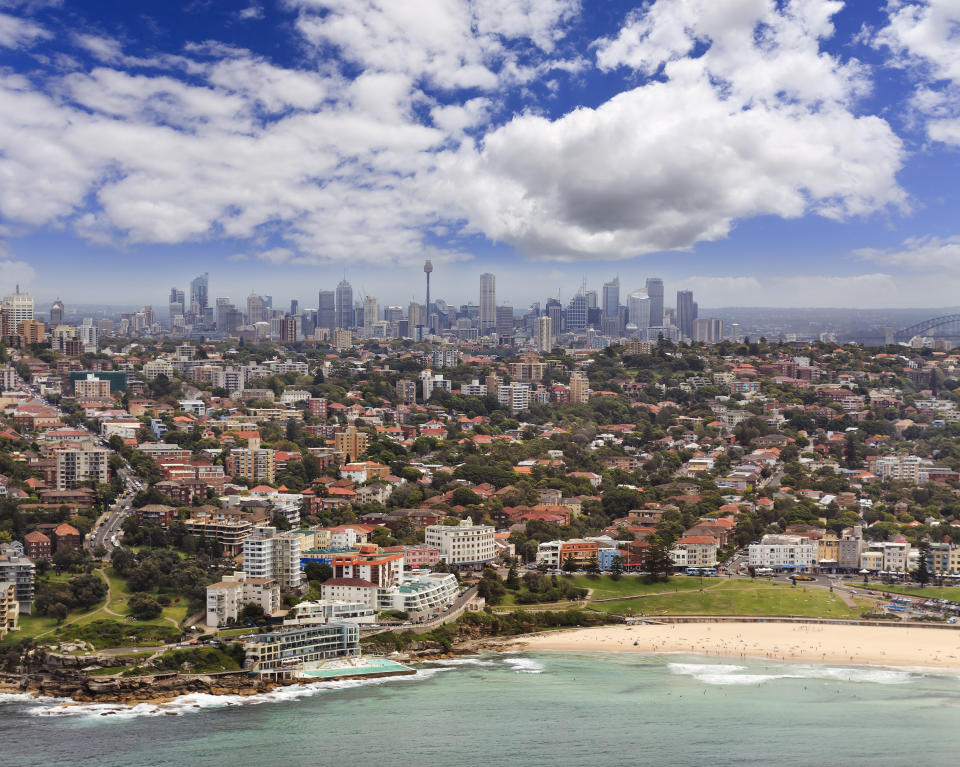 Elevated view of waterfront houses with the Sydney CBD in the background.