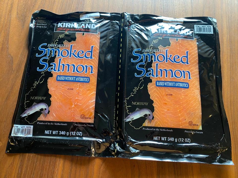 Black packs of costco's smoked salmon on wooden table