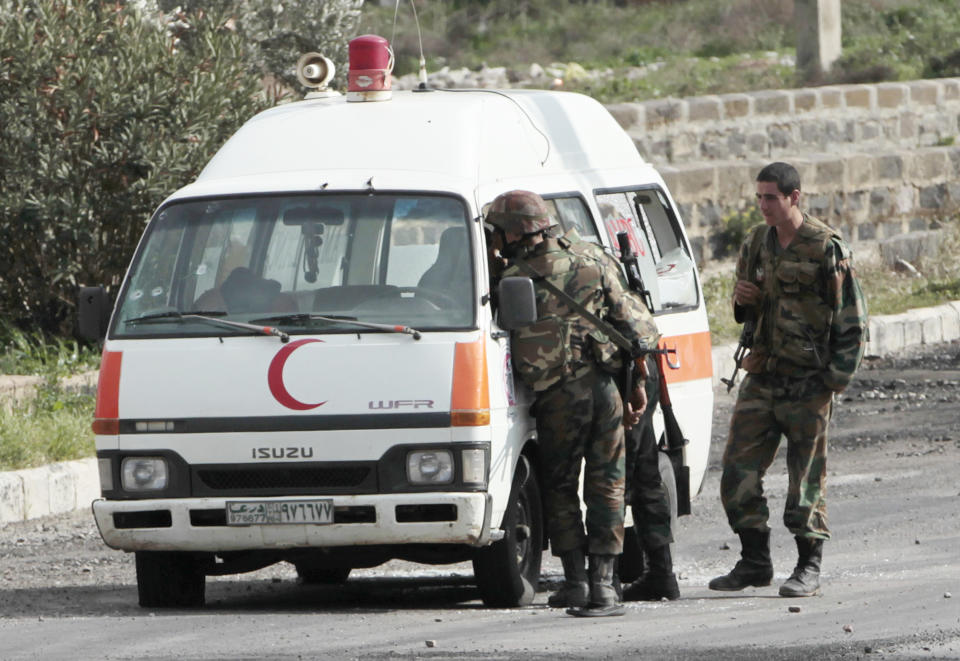 FILE - In this, March 23, 2011, file photo, Syrian soldiers check an ambulance in which a doctor and two paramedics were killed in an attack, according to the official Syrian television, in the southern city of Daraa, Syria. Security forces shot live ammunition and tear gas early that day near a mosque where protesters had been camped out, killing six people including a paramedic, activists said. (AP Photo/Hussein Malla, File)