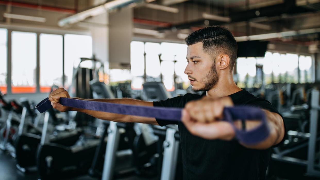  Man performing resistance band pull-apart  