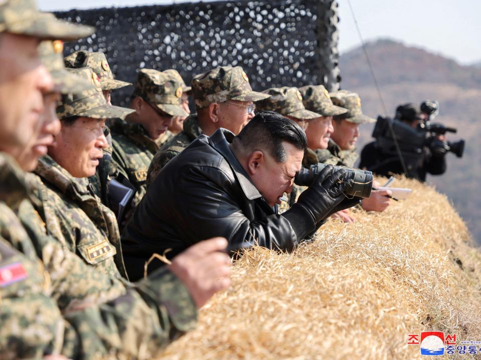 North Korean leader Kim Jong Un peers through a pair of binoculars during a military demonstration in North Korea.