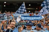 Fans hold up scarfs during an MLS game between Sporting Kansas City and Inter Miami at GEHA Field at Arrowhead Stadium on Saturday, April 13, 2024, in Kansas City.