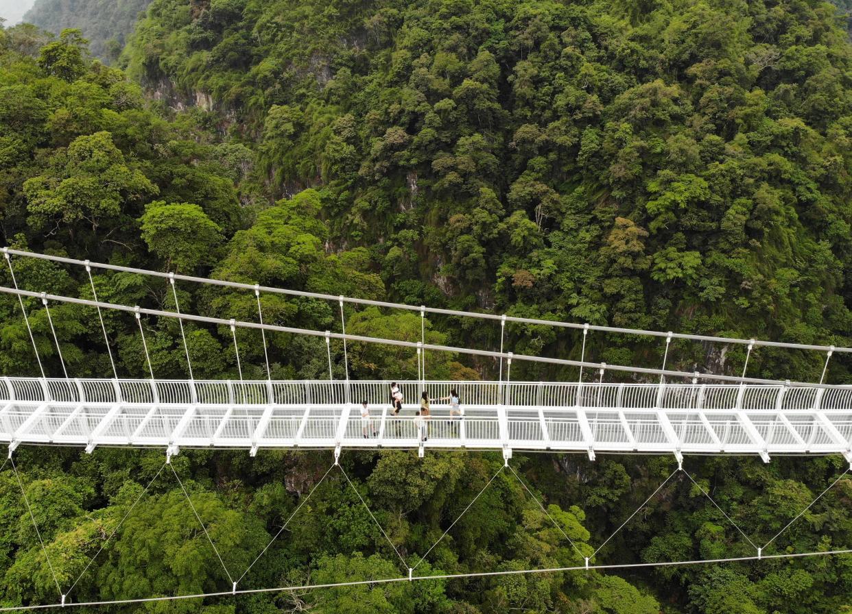 people walk on the Bach Long glass bridge in the Moc Chau district in Vietnam's Son La province