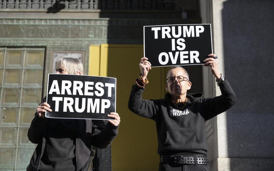 Protestors hold signs outside the office of Manhattan District Attorney Alvin Bragg - Fatih Aktas/Anadolu Agency