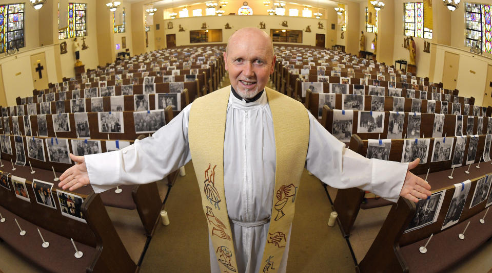 FILE - In this May 22, 2020, file photo, the Rev. Nicolas Sanchez Toledano poses among pews adorned with portraits of his parishioners at St. Patrick's Catholic Church during the coronavirus outbreak in the North Hollywood section of Los Angeles. California says churches can resume in-person services but the congregations will be limited to less than 100 and worshippers should wear masks, avoid sharing prayer books and skip the collection plate. The state Department of Public Health released a framework Monday, May 25, for county health officials to permit houses of worship to reopen. (AP Photo/Mark J. Terrill, File)