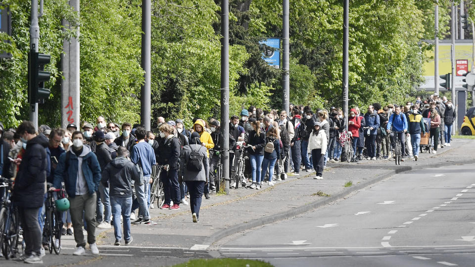 Several hundreds of people line up to receive an AstraZeneca vaccination against the coronavirus at the forum of the DITIB central mosque in Cologne, Germany, Saturday, May 8, 2021. (AP Photo/Martin Meissner)