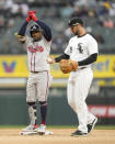 Atlanta Braves' Ozzie Albies celebrates towards the dugout as Chicago White Sox's Paul DeJong examines the ball after Albies' RBI double during the sixth inning of a baseball game Monday, April 1, 2024, in Chicago. Ronald Acuna Jr. scored on the play. (AP Photo/Charles Rex Arbogast)