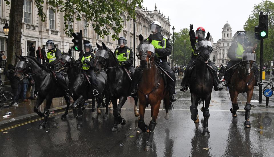 Mounted police officers charge their horses along Whitehall, past the entrance to Downing Street, in an attempt to disperse protestors gathered in central London on June 6, 2020, during a demonstration to show solidarity with the Black Lives Matter movement in the wake of the killing of George Floyd, an unarmed black man who died after a police officer knelt on his neck in Minneapolis. - The United States braced Friday for massive weekend protests against racism and police brutality, as outrage soared over the latest law enforcement abuses against demonstrators that were caught on camera. With protests over last week's police killing of George Floyd, an unarmed black man, surging into a second weekend, President Donald Trump sparked fresh controversy by saying it was a "great day" for Floyd. (Photo by DANIEL LEAL-OLIVAS / AFP) (Photo by DANIEL LEAL-OLIVAS/AFP via Getty Images)