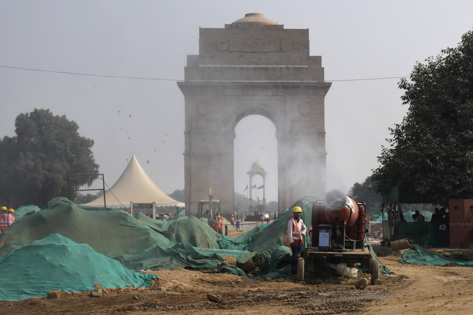 A worker uses an anti-smog gun to control dust at a construction side at the landmark India Gate monument in New Delhi, India, Thursday, Nov. 18, 2021. Air pollution remained extremely high in the Indian capital on Thursday, a day after authorities closed schools indefinitely and shut some power stations to reduce smog that has blanketed the city for much of the month. (AP Photo/Manish Swarup)
