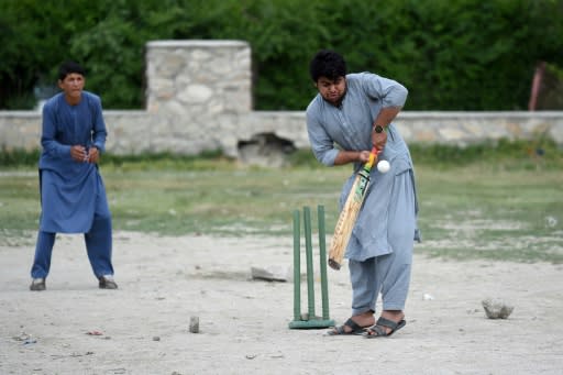 Afghans play cricket on rough ground in Kabul