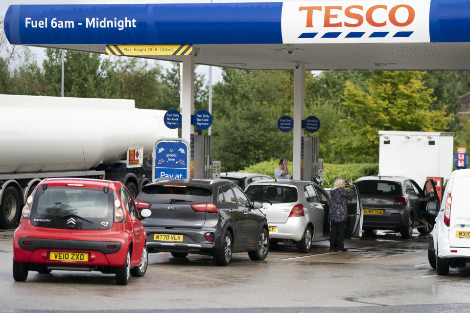 Members of the public are seen at a petrol station in Manchester, England, Monday, Sept. 27, 2021. British Prime Minister Boris Johnson is said to be considering whether to call in the army to deliver fuel to petrol stations as pumps ran dry after days of panic buying. ( AP Photo/Jon Super)
