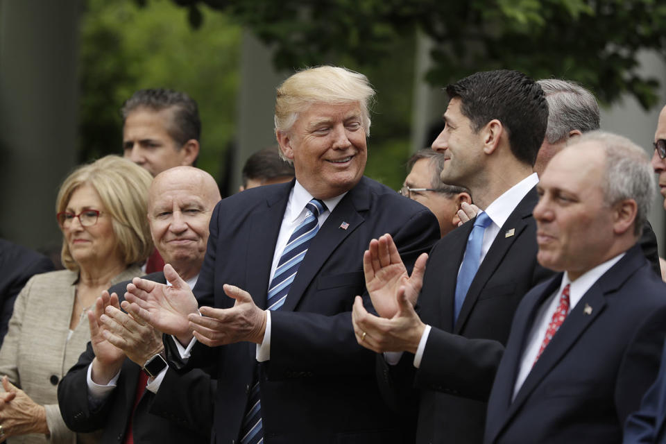 <p>President Trump, flanked by House Ways and Means Committee Chair Kevin Brady and House Speaker Paul Ryan applaud at the White House on May 4, 2017, after the House pushed through a health care bill. (Photo: Evan Vucci/AP) </p>