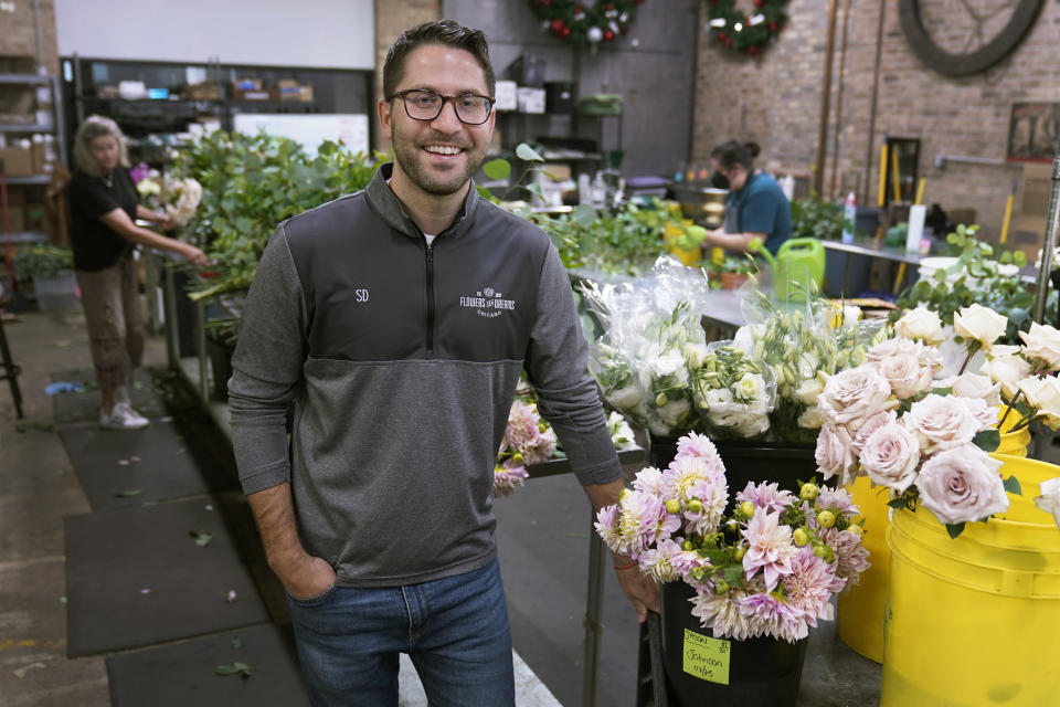 Steven Dyme, owner of Flowers for Dreams, poses for a portrait at his warehouse Friday, July 23, 2021, in Chicago. Dyme says the $15 minimum made it much easier to staff up when the economy reopened this spring and demand for flowers, particularly for weddings, soared. The company has four locations, including its headquarters in Chicago, one in Milwaukee, and two in Detroit. (AP Photo/Charles Rex Arbogast)