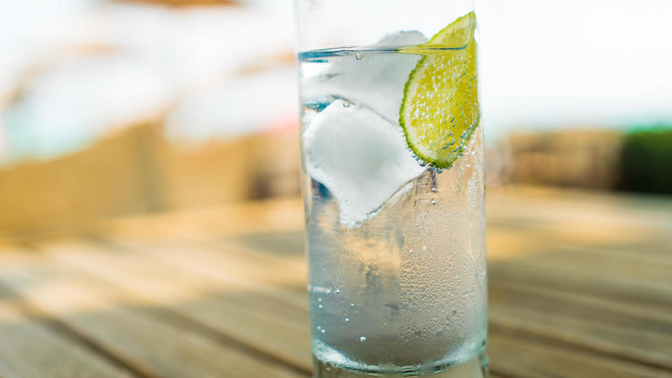 Close up of a refreshing ice cold glass of water with a slice of lime.