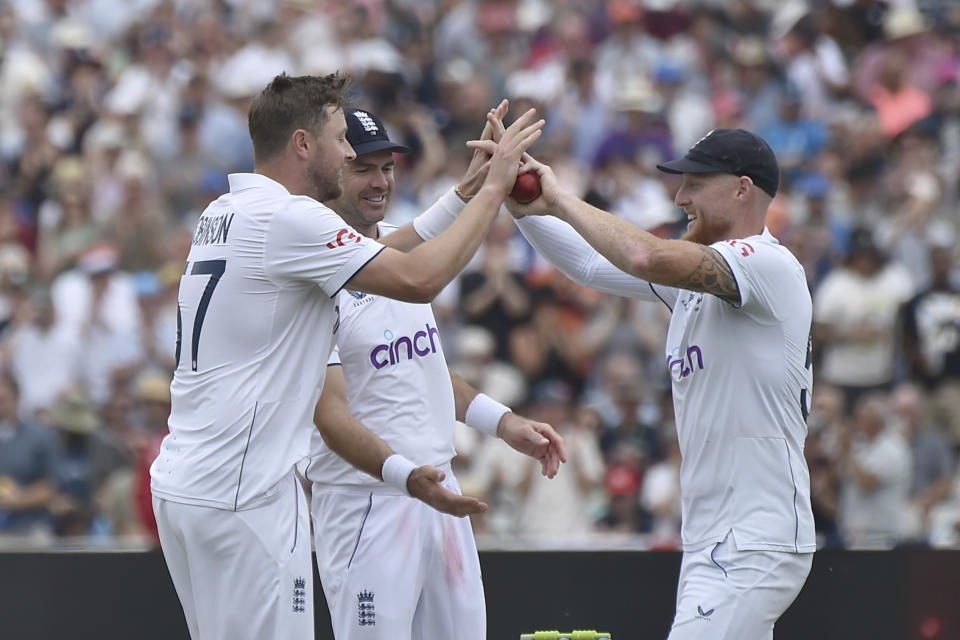 England's Ollie Robinson, left, celebrates with England's Ben Stokes after taking the wicket of Australia's Pat Cummins to end the Australian 1st innings during day three of the first Ashes Test cricket match between England and Australia at Edgbaston, Birmingham, England, Sunday, June 18, 2023. Australia train England by 7 runs. (AP Photo/Rui Vieira)