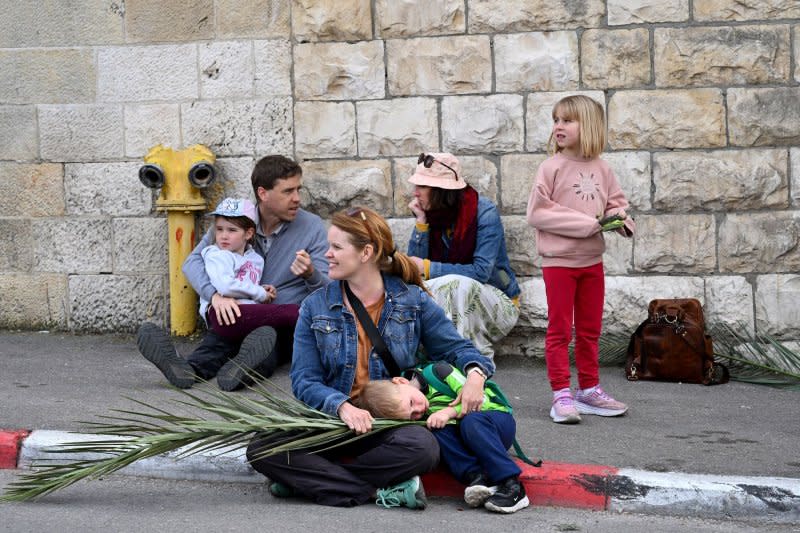 Christians wait for the traditional Palm Sunday procession on the Mt. Of Olives, overlooking the Old City of Jerusalem, East Jerusalem, on Sunday, March 24, 2024. Photo by Debbie Hill/ UPI