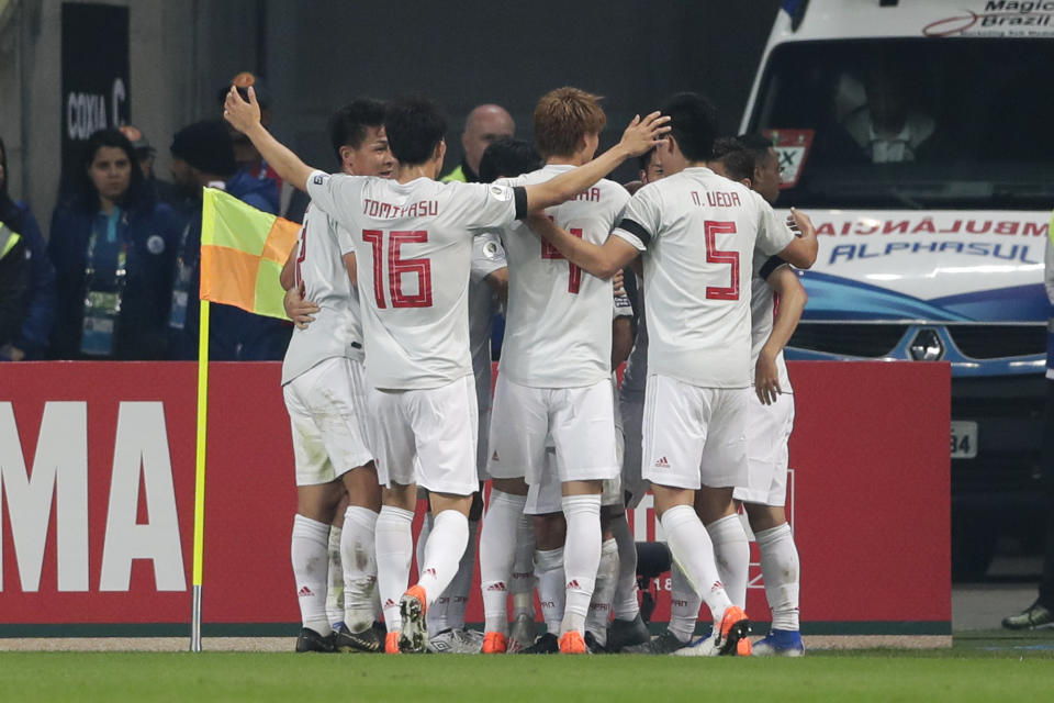Japan players celebrate the goal of Koji Miyoshi, standing behind teammates, during a Copa America Group C soccer match against Colombia at the Arena Gremio in Porto Alegre, Brazil, Thursday, June 20, 2019. (AP Photo/Silvia Izquierdo)
