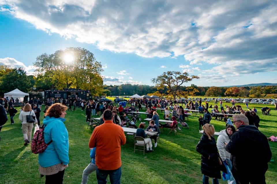The sun starts to set as visitors stop by the food court at The Arboretum at Penn State Pumpkin Festival on Saturday, Oct. 8, 2022.