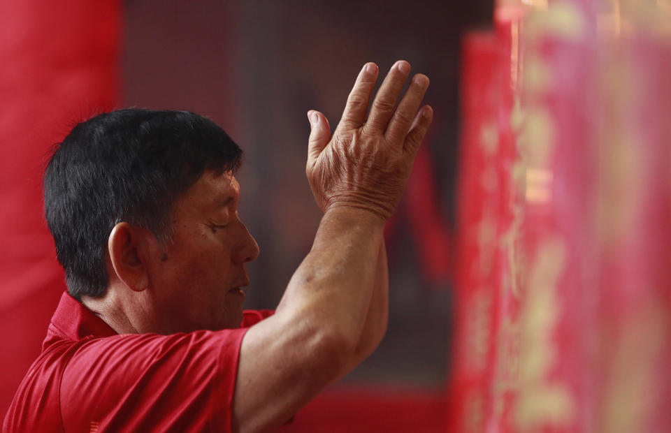 An ethnic Chinese man prays during celebrations of the Lunar New Year at the Dharma Bakti Temple in Jakarta, Indonesia, Saturday, Jan. 28, 2017. Ethnic Chinese in the world's most populous Muslim country are celebrating the Year of the Rooster. (AP Photo/Achmad Ibrahim)