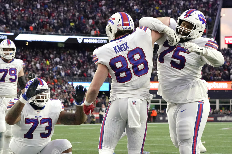 Buffalo Bills tight end Dawson Knox (88) celebrates with offensive tackle Daryl Williams (75) after his touchdown against the New England Patriots during the second half of an NFL football game, Sunday, Dec. 26, 2021, in Foxborough, Mass. At left is Buffalo Bills offensive tackle Dion Dawkins (73). (AP Photo/Steven Senne)
