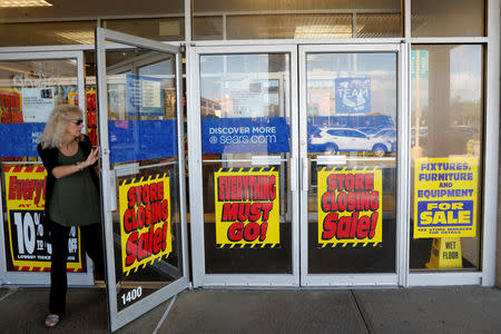 FILE PHOTO: A woman walks out of closing down sale at a Sears store in New Hyde Park, New York, on Oct. 10, 2018. REUTERS/Shannon Stapleton/File Photo