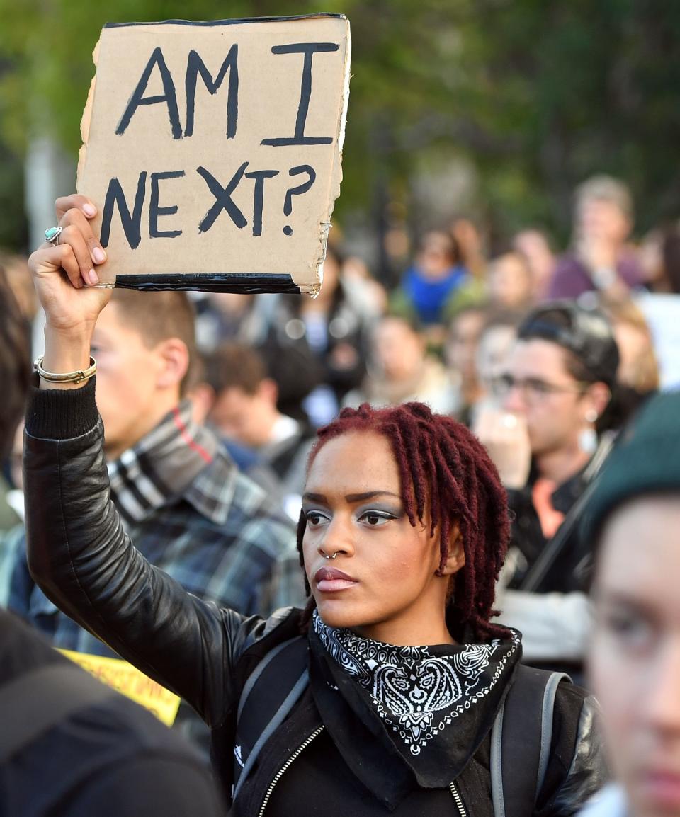 A woman holds up a sign during a rally at Justin Herman Plaza to denounce recent police shootings around the country, in San Francisco, California on July 8, 2016.&nbsp;