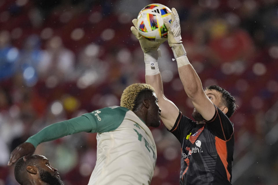 FC Dallas goalkeeper Maarten Paes, right, makes a save against Austin FC forward Gyasi Zardes, second from right, during the second half of an MLS soccer match Saturday, May 11, 2024, in Frisco, Texas. (AP Photo/LM Otero)