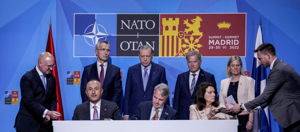 From left to right background: NATO Secretary General Jens Stoltenberg, Turkish President Recep Tayyip Erdogan, Finland's President Sauli Niinisto, Sweden's Prime Minister Magdalena Andersson, Turkish Foreign Minister Mevlut Cavusoglu, Finnish Foreign Minister Pekka Haavisto, and Sweden's Foreign Minister Ann Linde sign a memorandum in which Turkey agrees to Finland and Sweden's membership of the defense alliance in Madrid, Spain on Tuesday, June 28, 2022. North Atlantic Treaty Organization heads of state will meet for a summit in Madrid from Tuesday through Thursday. (AP Photo/Bernat Armangue)