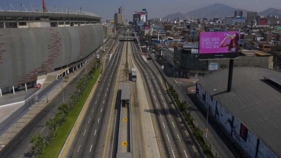 People ride bicycles in an empty highway in Lima, Peru, Sunday, Jan. 31, 2021. Peruvian authorities are instituting a complete lockdown in multiple regions including the capital due to a resurgence in COVID-19 cases that has taxed healthcare services to their maximum capacity. (AP Photo/Rodrigo Abd)