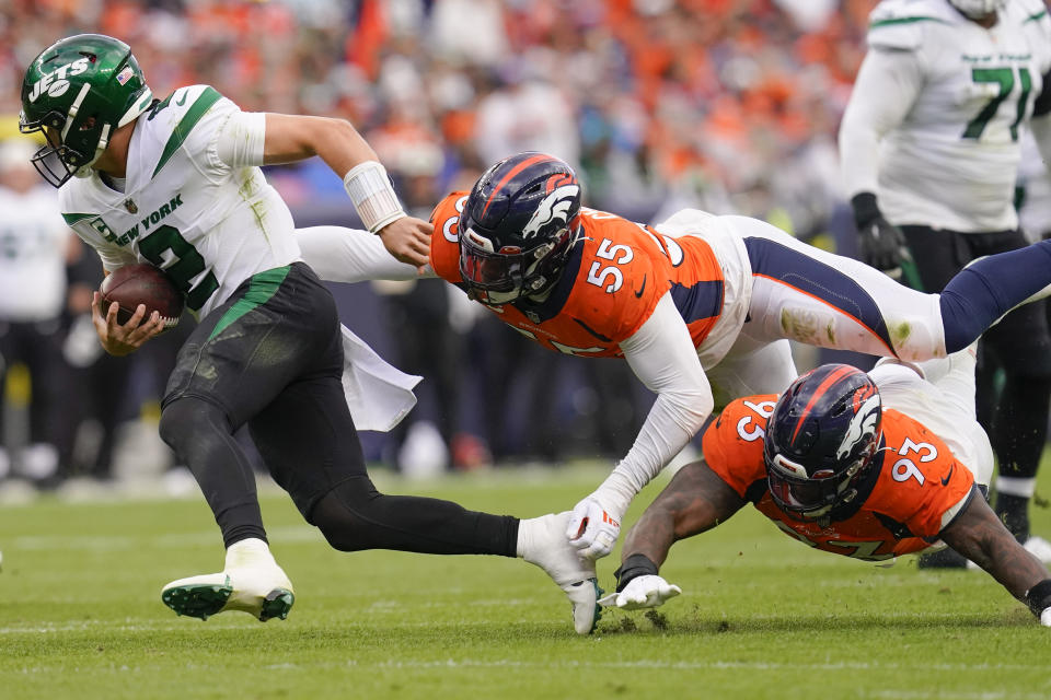 New York Jets quarterback Zach Wilson (2) avoids the sack by Denver Broncos' Dre'Mont Jones (93) and Bradley Chubb (55) during the second half of an NFL football game, Sunday, Oct. 23, 2022, in Denver. (AP Photo/Matt York)