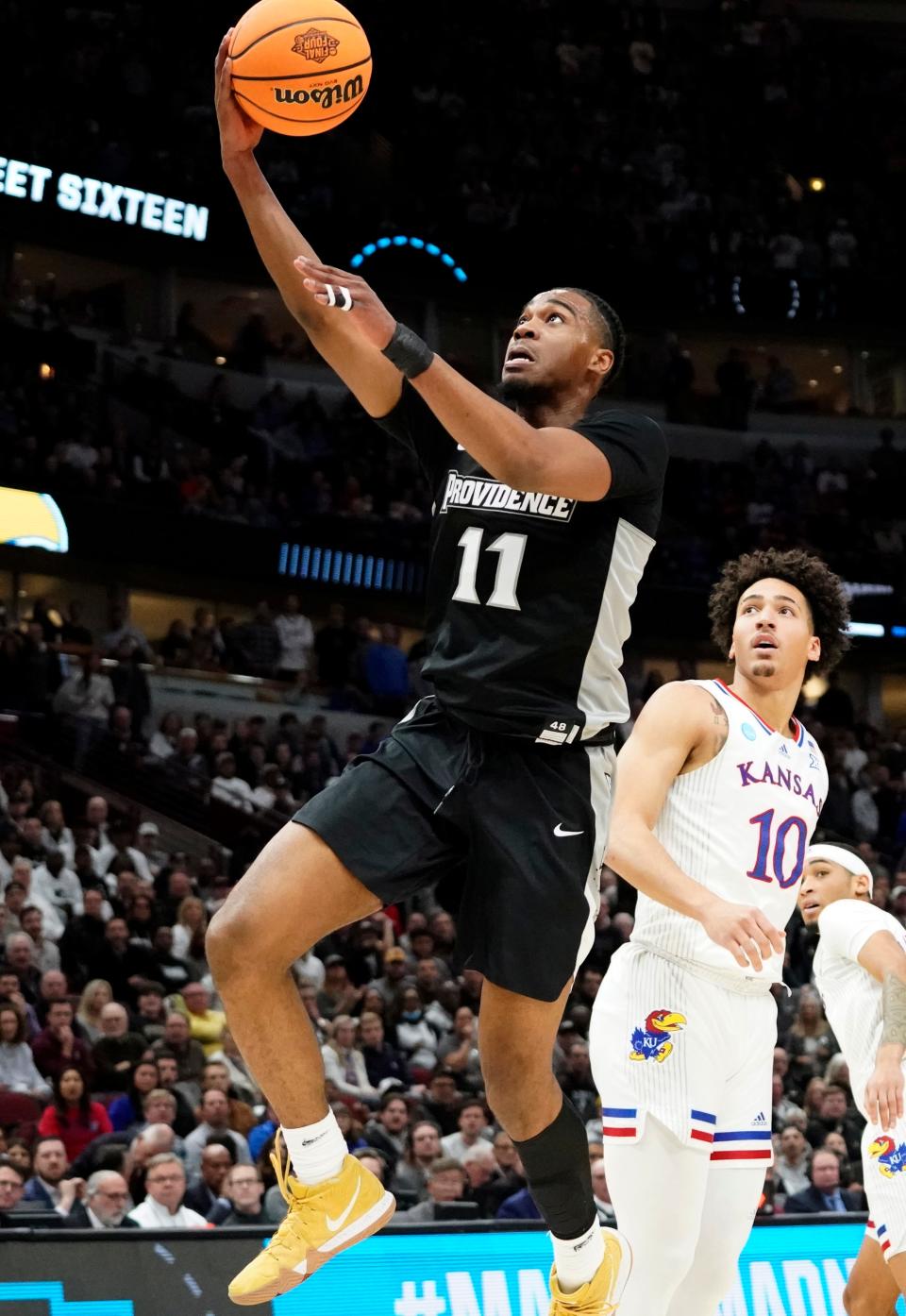 Mar 25, 2022; Chicago, IL, USA; Providence Friars guard A.J. Reeves (11) drives past Kansas Jayhawks forward Jalen Wilson (10) during the first half in the semifinals of the Midwest regional of the men's college basketball NCAA Tournament at United Center. Mandatory Credit: David Banks-USA TODAY Sports